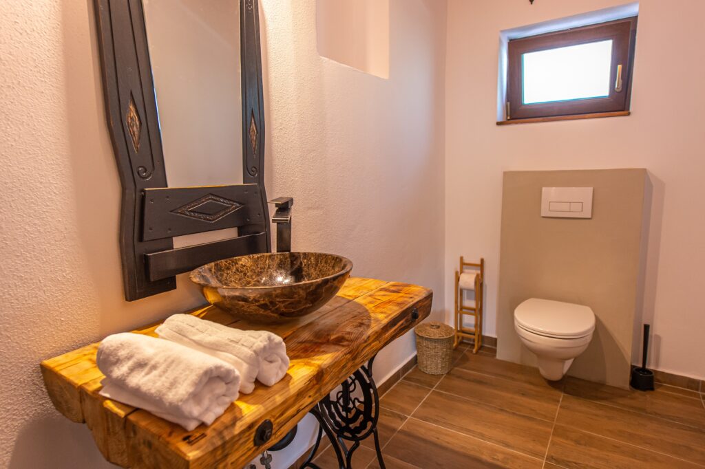 Chiuvetă cu mobilier rustic din lemn în baia pensiunii Old Barn House