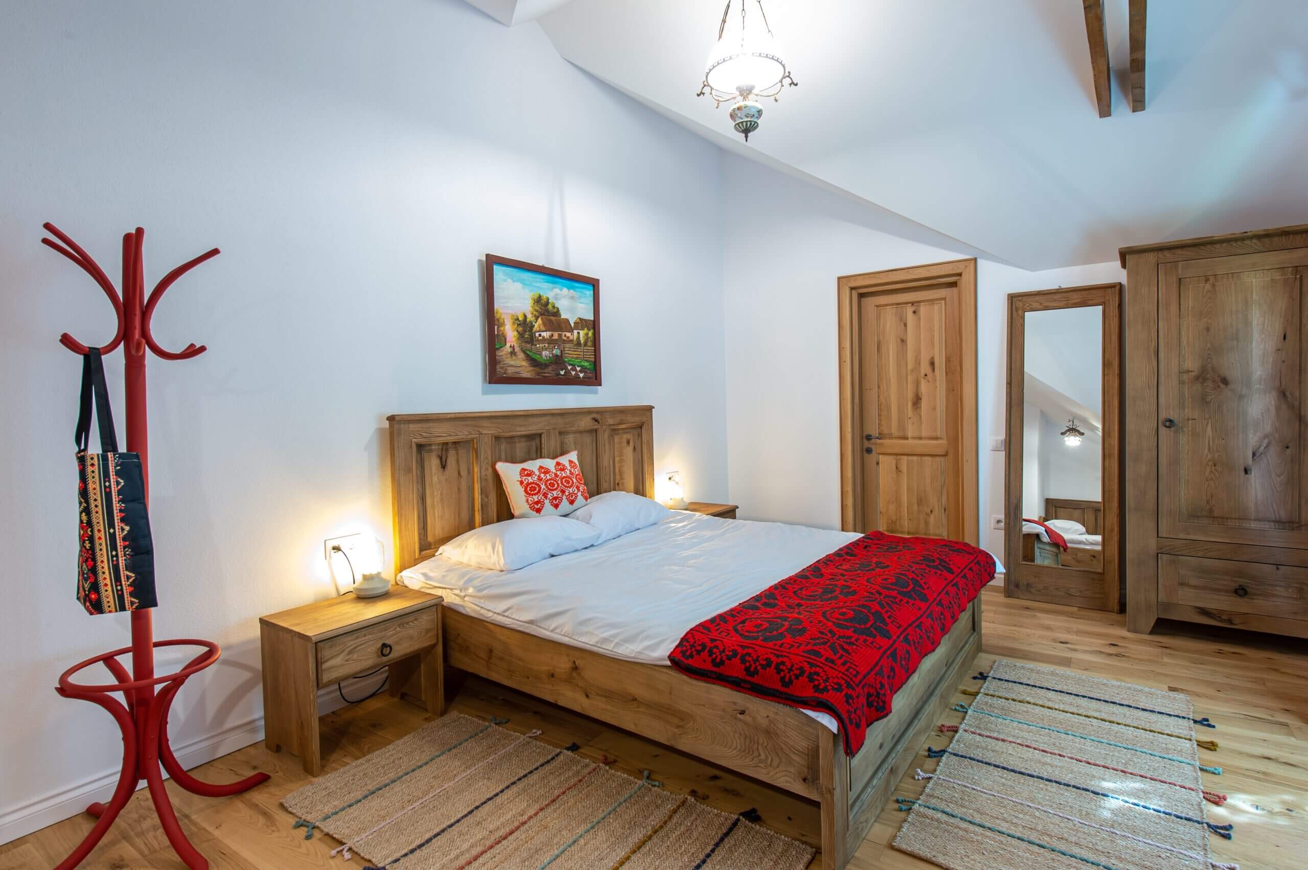 Pat matrimonial din lemn masiv în camera pensiunii Old Barn House, Chinari